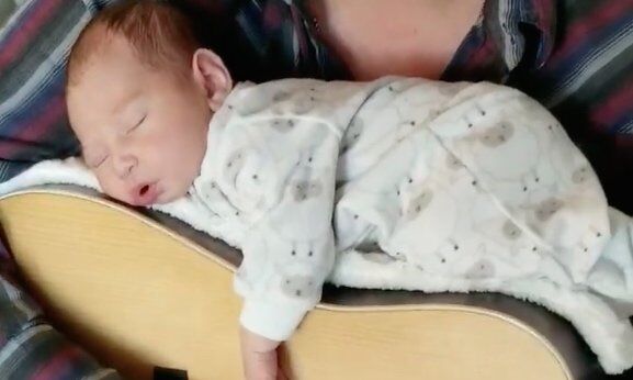 video vader sust baby in slaap met gitaar