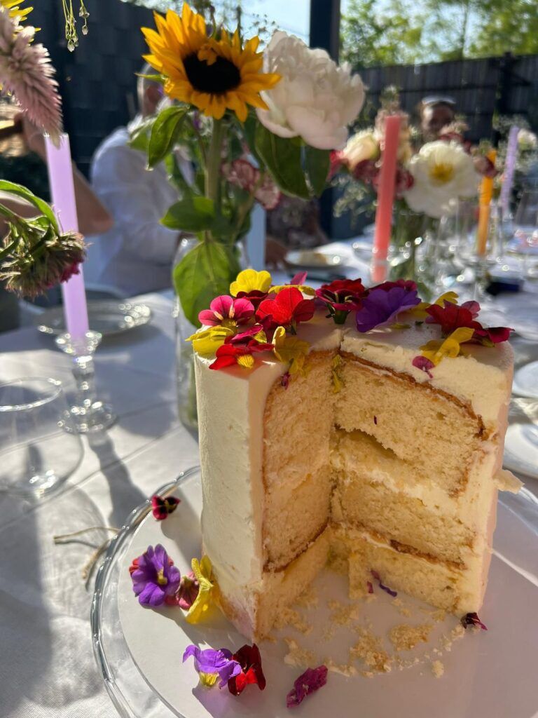 Met bloemen versierde taart op een gedekte tafel tijdens een 21 diner.